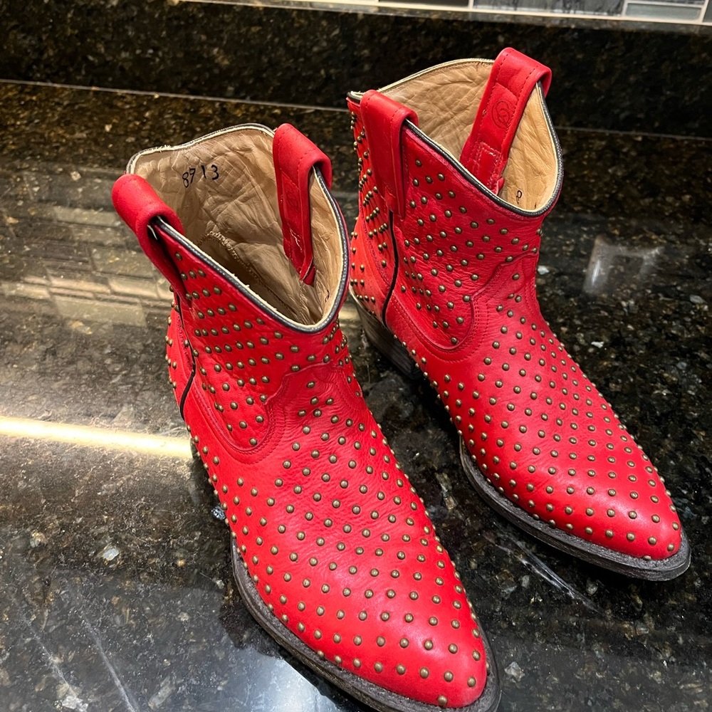 Red leather ankle boots with brass studs.